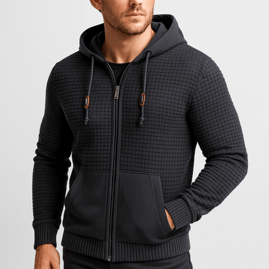 Man wearing a black textured zip-up hoodie on a light gray background