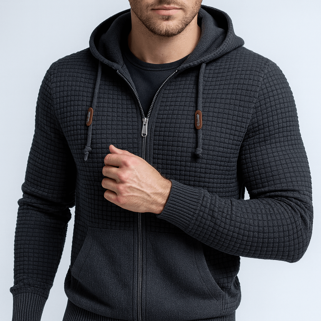 Man wearing a dark gray textured hoodie with a zipper on a light gray background