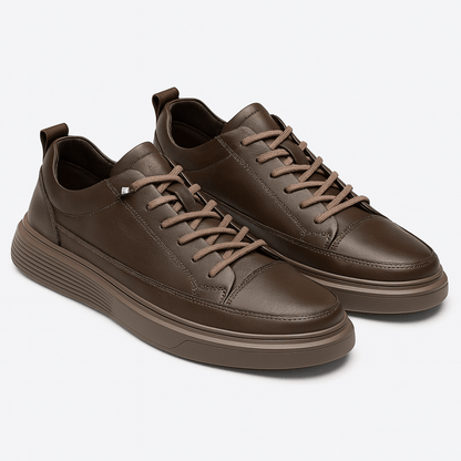 Pair of brown leather sneakers on a light gray background