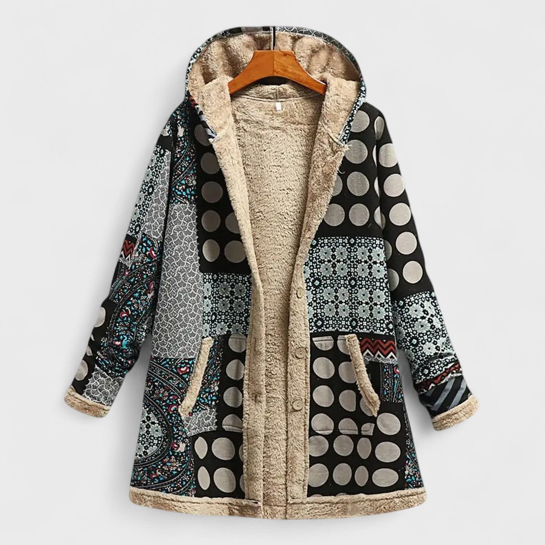 Patterned coat with a hood on a hanger against a white background