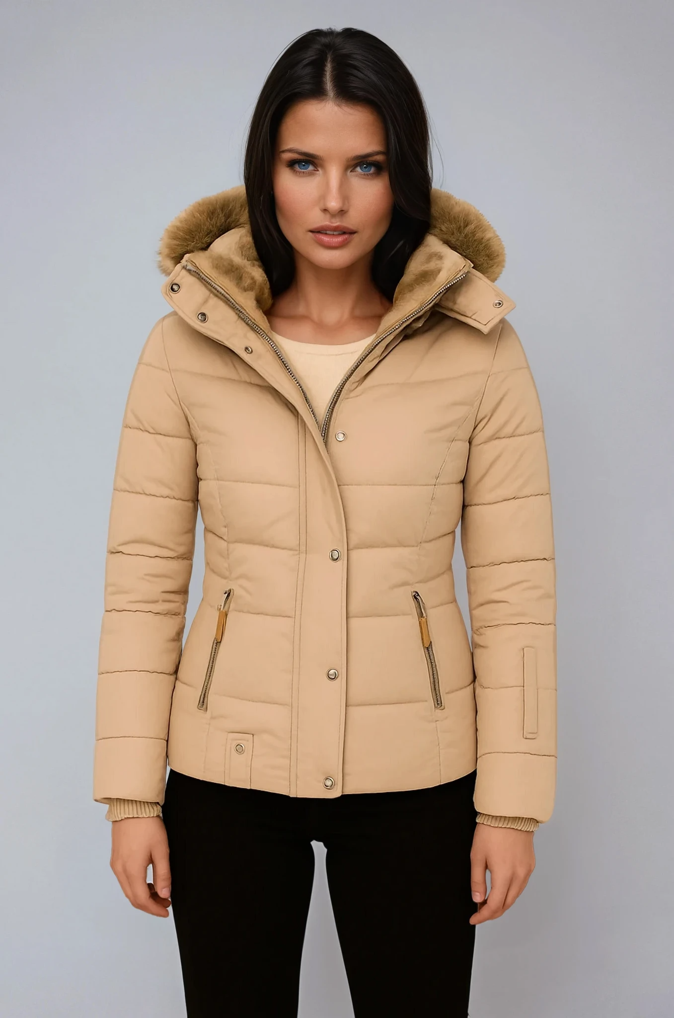 Woman wearing a beige puffer jacket with fur hood on a gray background