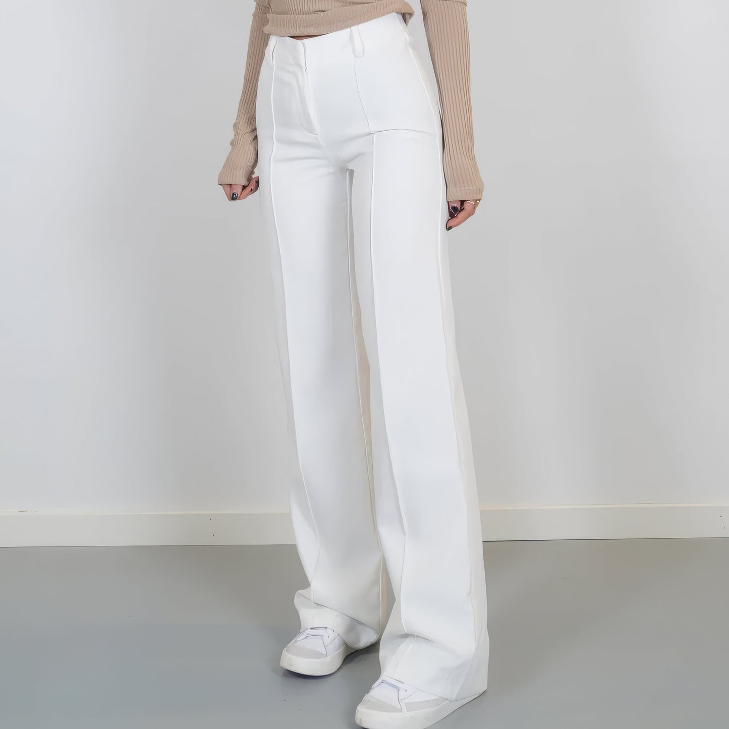 White pants worn by a person on a plain background