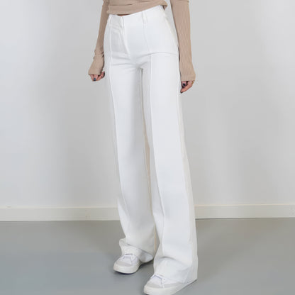White pants worn by a person on a plain background