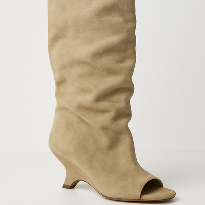 Beige knee-high boot with a slight heel on a light gray background