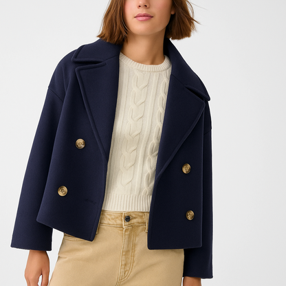 Navy blue coat with gold buttons worn by a person on a white background