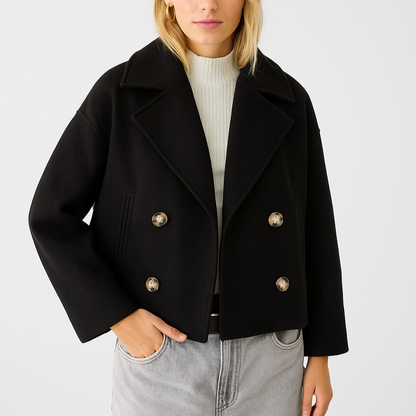 Black peacoat with gold buttons worn by a person on a light gray background