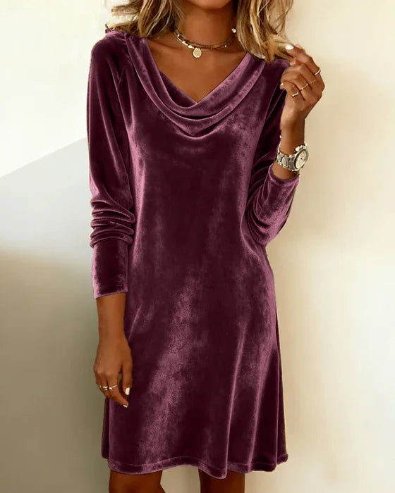 Purple velvet dress worn by a person against a plain background