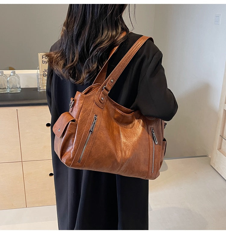 Person wearing a brown leather backpack indoors