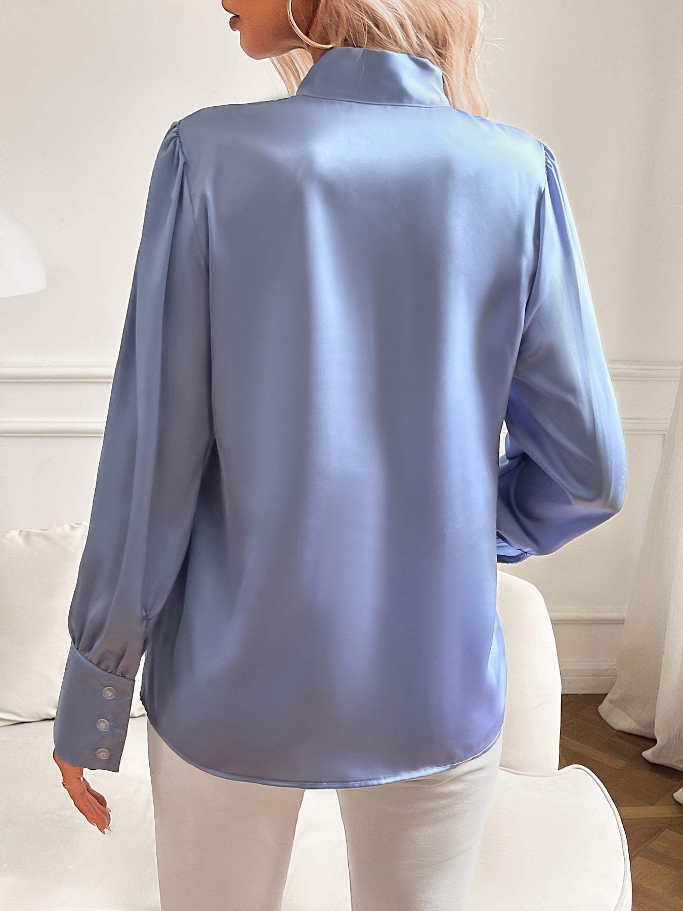 Blue satin shirt worn by a person in a neutral indoor setting