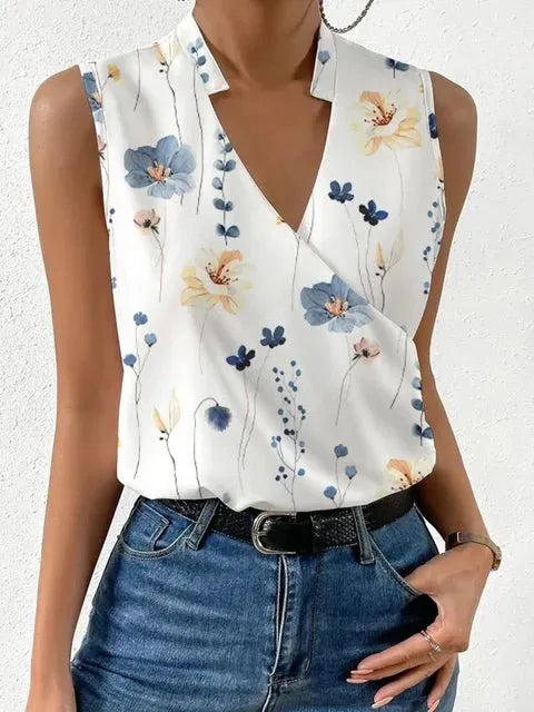 White sleeveless top with floral pattern worn by a person, paired with blue jeans on a white background