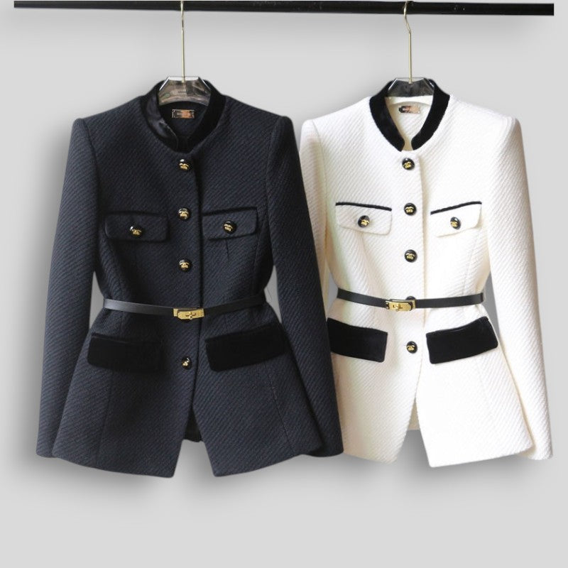 Two jackets, one black and one white, on hangers against a plain background.