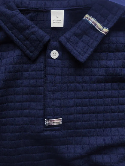Navy quilted jacket with plaid trim and button detail, brand label visible.