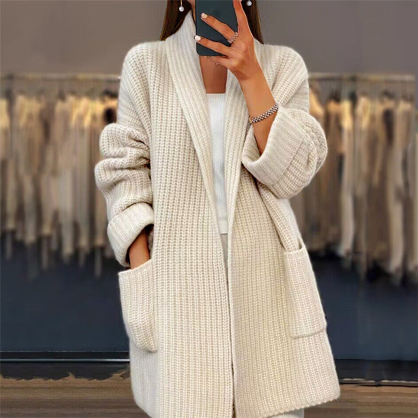 Person wearing a beige knitted cardigan in a clothing store.