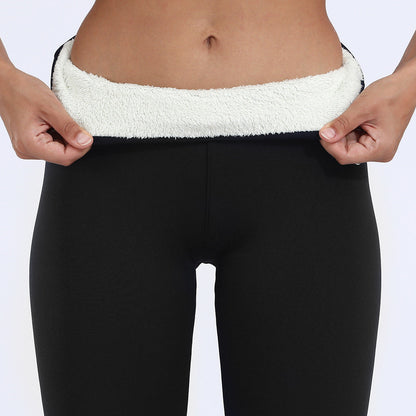 Black leggings with white fleece lining held up by hands on a light gray background
