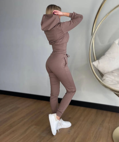 Person wearing a brown tracksuit standing in front of a mirror.