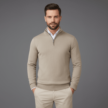 Man wearing a beige sweater and pants against a gray background