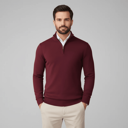 Man wearing a burgundy pullover with a white shirt underneath on a gray background