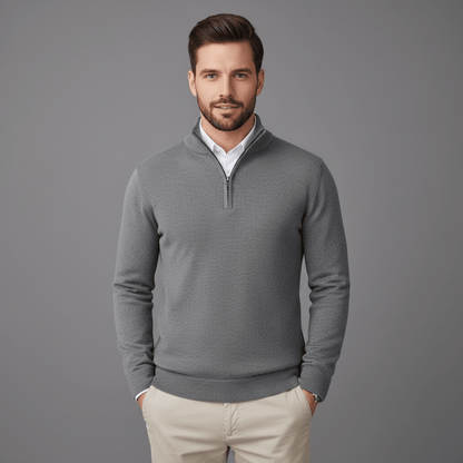 Man wearing a gray quarter-zip sweater against a gray background