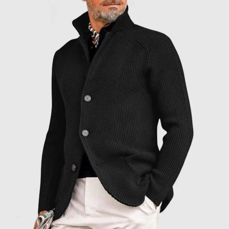 Man wearing a black knitted cardigan on a light gray background