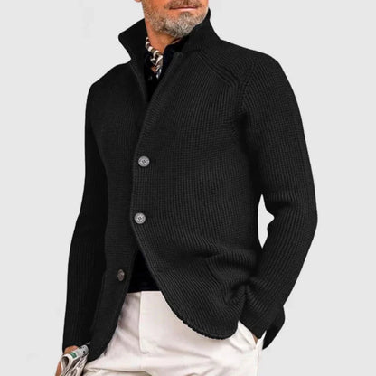 Man wearing a black knitted cardigan on a light gray background