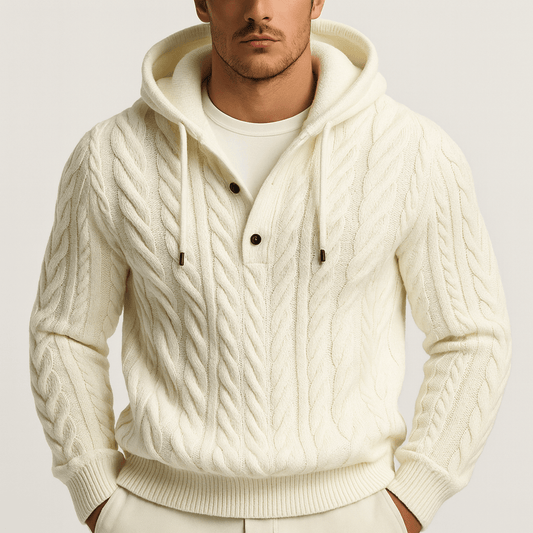 Man wearing a cream-colored cable knit hoodie on a light gray background