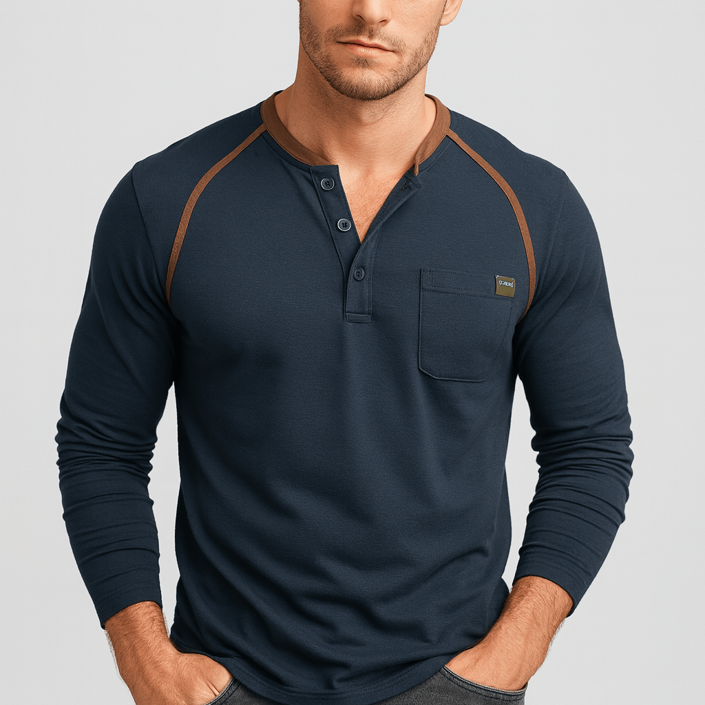 Man wearing a navy long-sleeve henley shirt with brown accents on a light gray background