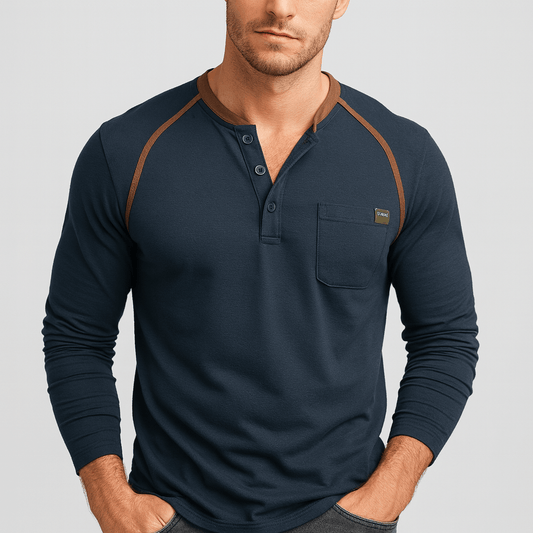 Man wearing a navy long-sleeve henley shirt with brown accents on a light gray background
