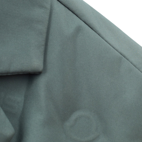 Close-up of textured green fabric with a brand logo.