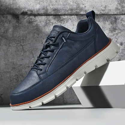 Navy blue leather sneaker with white sole on a gray background
