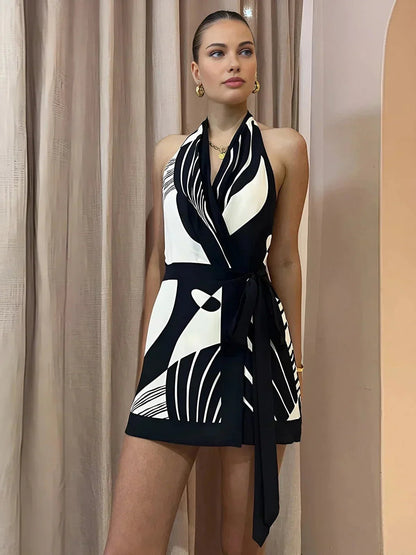Woman wearing a black and white patterned dress against a beige curtain background