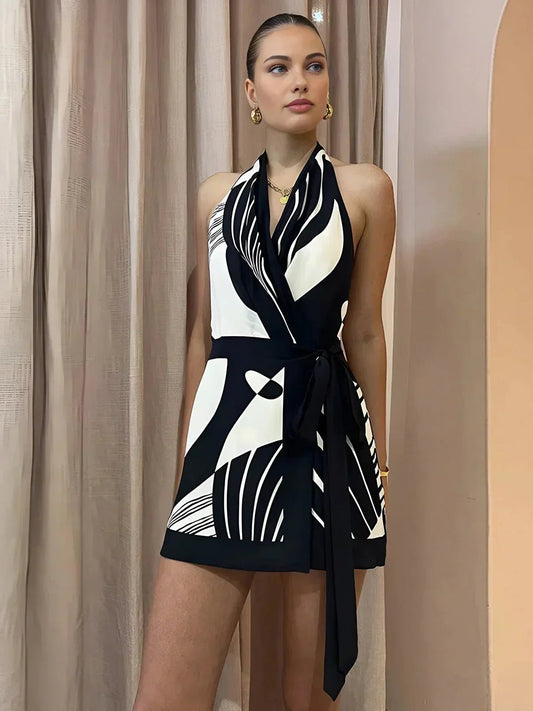 Woman wearing a black and white patterned dress against a beige curtain background