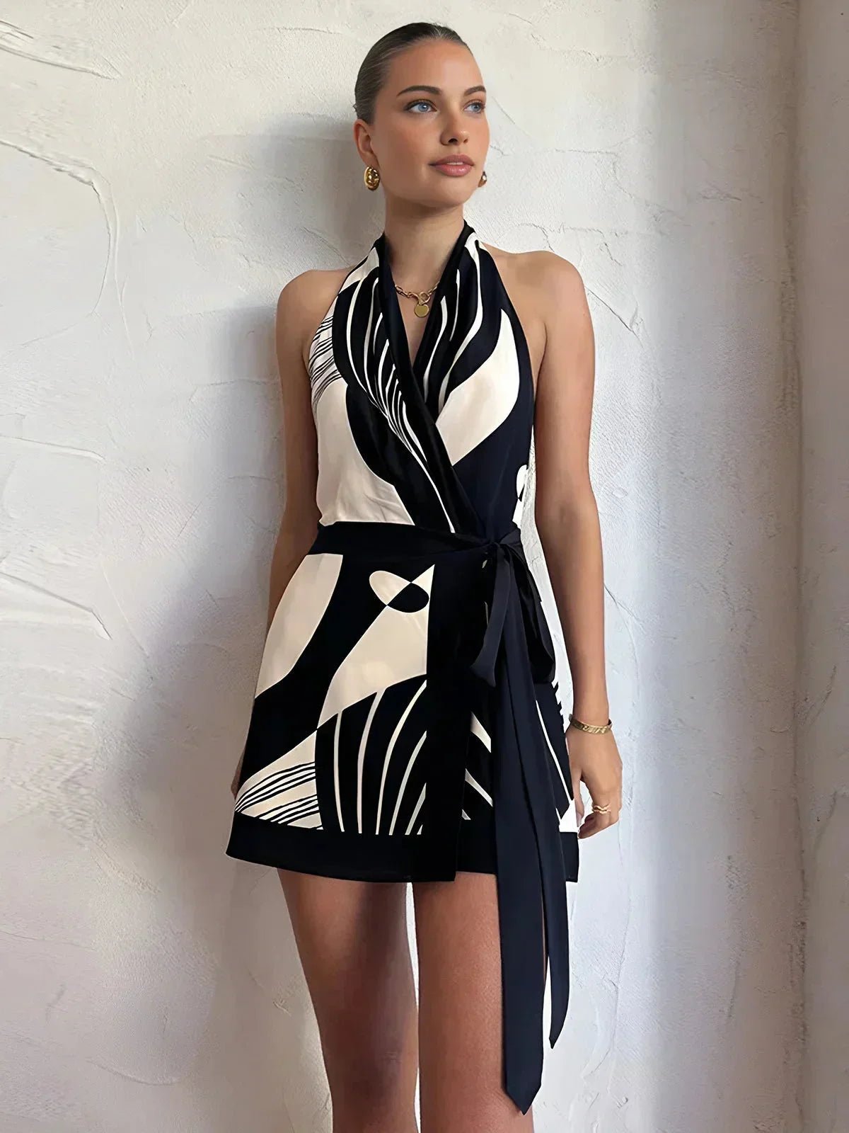 Woman wearing a black and white patterned dress against a plain background