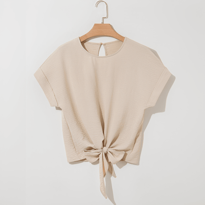 Beige top with knot detail on a hanger against a white background