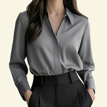 Gray blouse and black pants on a neutral background