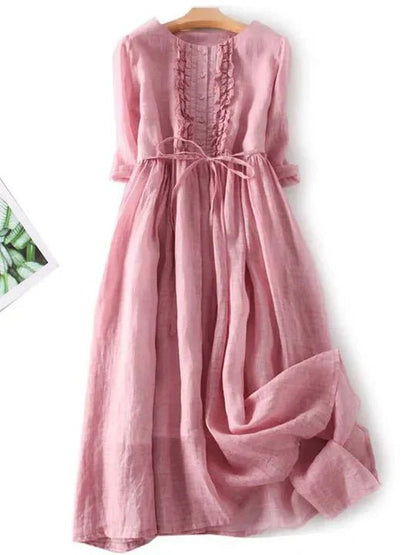 Pink dress on a hanger with a white background