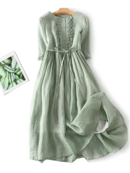 Green dress on a white background with a small inset of green leaves.