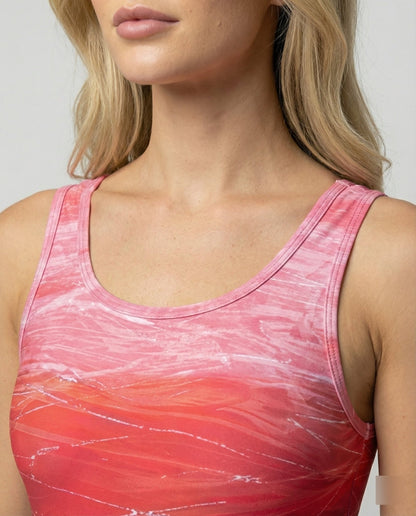 Woman wearing a pink and red patterned tank top against a neutral background