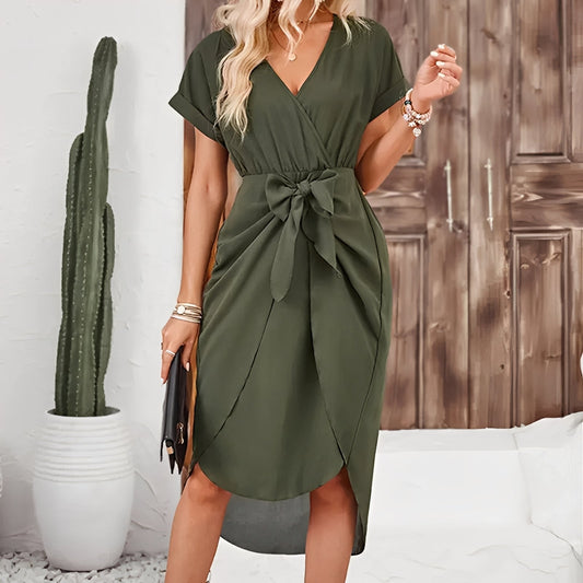 Woman wearing a green dress with a wooden panel and cactus in the background