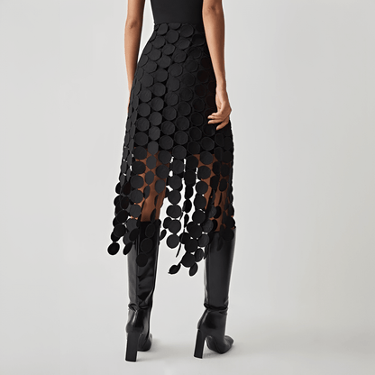 Black patterned skirt worn by a person on a plain background