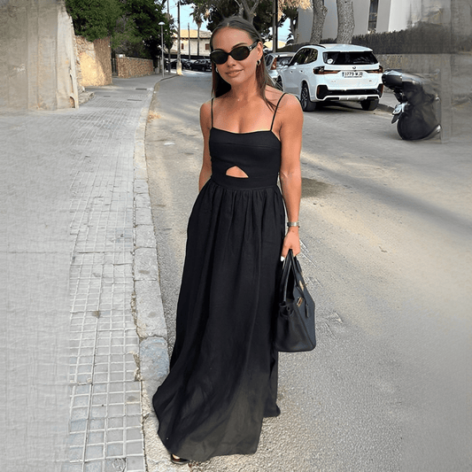 Woman in a black dress standing on a street