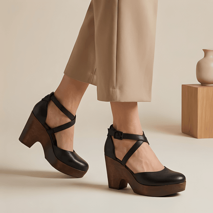 Brown platform shoes worn with beige pants on a neutral background