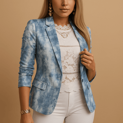Woman wearing a blue patterned blazer over a white lace top and pants on a beige background