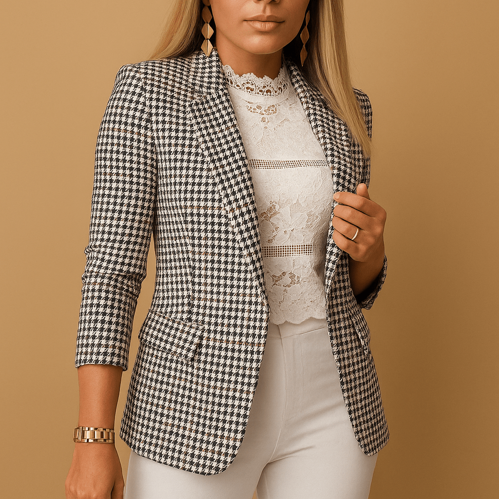 Woman wearing a black and white checkered blazer over a lace top on a beige background