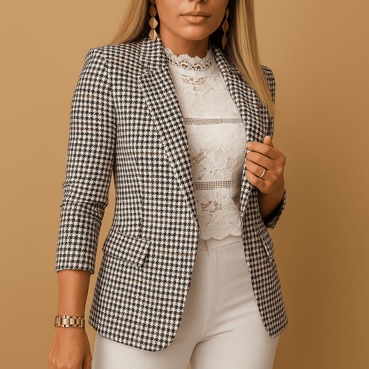 Woman wearing a black and white checkered blazer over a lace top on a beige background