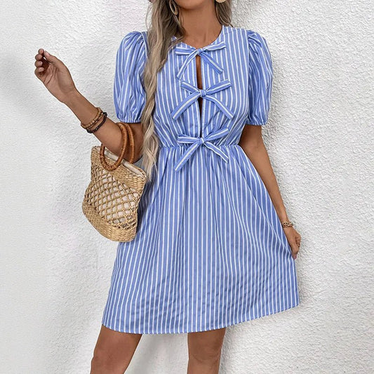 Woman wearing a blue and white striped dress with a textured white background