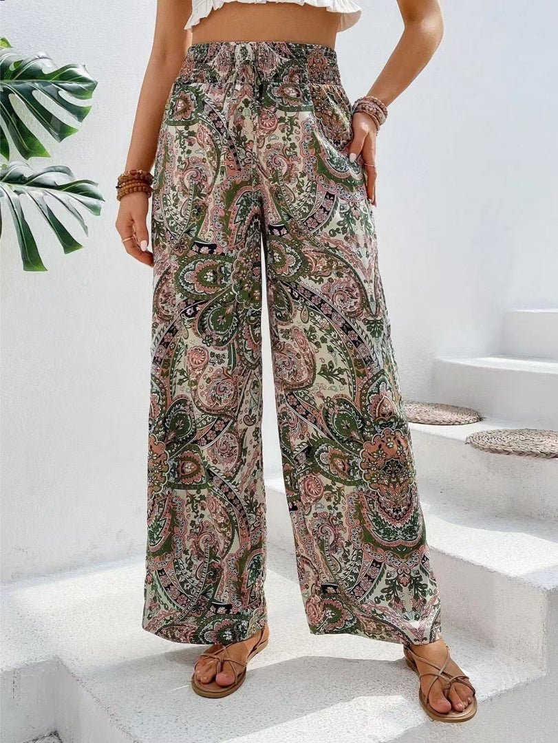 Person wearing paisley patterned wide-leg pants on a white staircase.