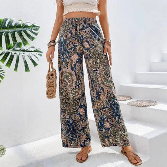 Person wearing patterned pants standing on a white staircase with greenery in the background