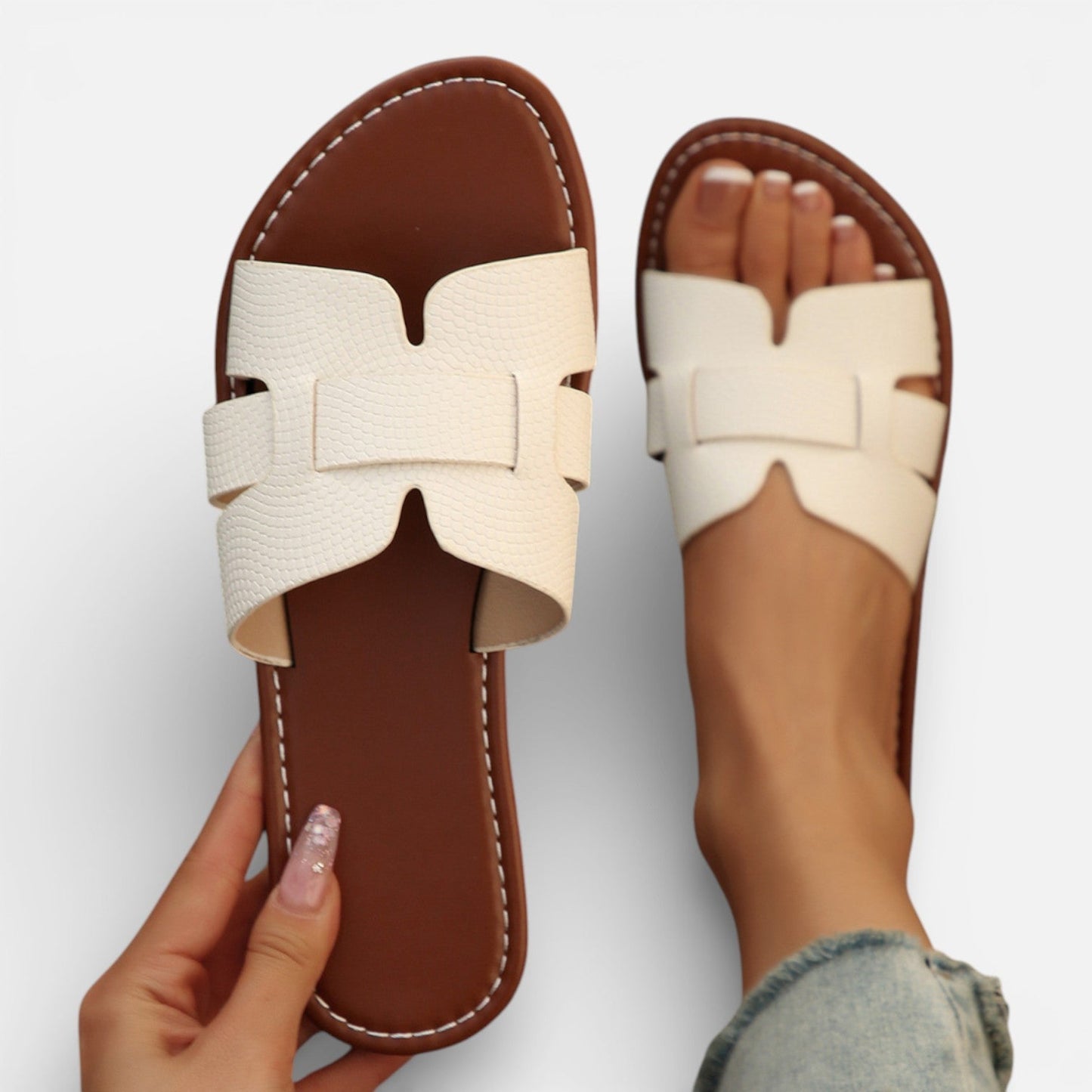 Pair of sandals with a bow detail on a white background