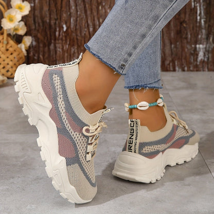 Beige and blue sneakers worn with jeans on a neutral background