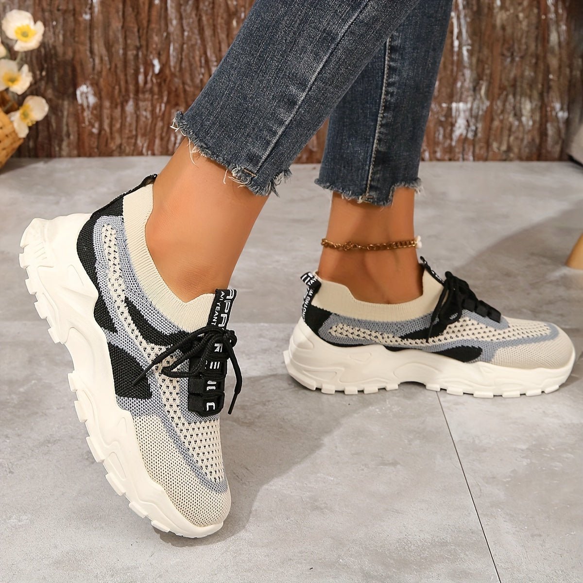 Sneakers worn with jeans on a concrete floor